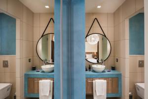 a bathroom with two sinks and a mirror at Sea & City Apartments in Chania Town