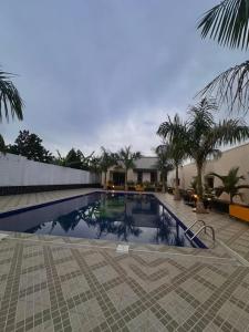 a swimming pool with palm trees next to a building at Pieme hotel residence 