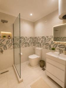 a bathroom with a shower and a toilet and a sink at Garden Hotel Nile House in Cairo