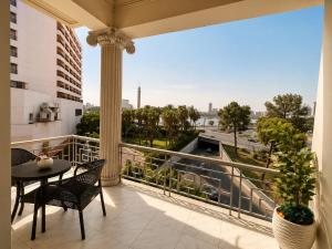 a balcony with a table and chairs and a view of the city at Garden Hotel Nile House in Cairo