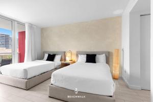 two beds in a hotel room with white sheets at Pininfarina Studio Intracoastal View in Hallandale Beach
