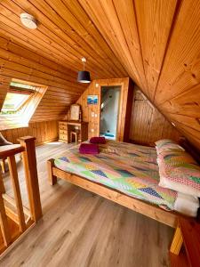 a bed in a wooden room in a cabin at Lochside Lodge in Dallavich