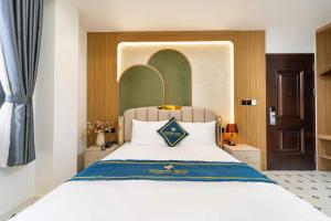 a bedroom with a large white bed with a blue pillow at Diamond Hotel in Bien Hoa