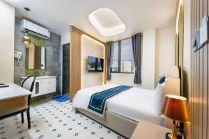 a bedroom with a bed and a desk and a sink at Diamond Hotel in Bien Hoa +38 photos