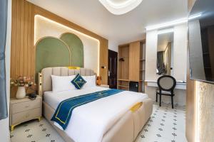 a bedroom with a large white bed and a chair at Diamond Hotel in Bien Hoa