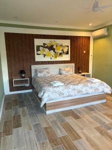 a bedroom with a large bed with yellow flowers on the wall at Appartement Zen VIP Péreybère in Grand-Baie