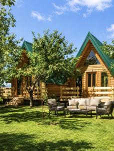 Eine Blockhütte mit Sofas und einem Baum im Garten in der Unterkunft Tiny House 4-Imanje Terzic in Golubovci
