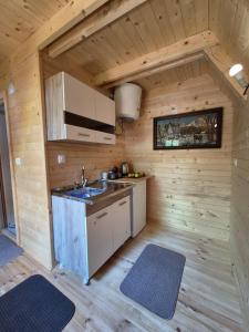 eine Küche in einer Holzhütte mit Spüle in der Unterkunft Tiny House 4-Imanje Terzic in Golubovci + 5 Fotos