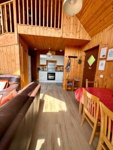 a living room with a couch and a table at Lochside Lodge in Dallavich