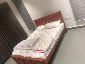 a bed with a wooden frame with towels on it at Coorg Family Villa in Gonikoppal