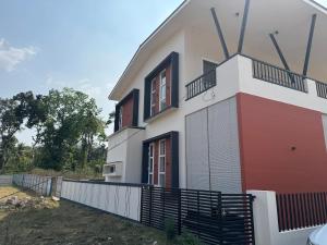 a white and red house with a fence around it at Coorg Family Villa in Gonikoppal
