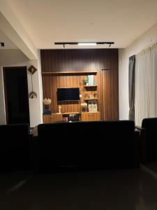 a living room with a flat screen tv and a couch at Coorg Family Villa in Gonikoppal