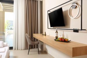 a hotel room with a desk with a television on a wall at Sophe Boutique Stay 2 in Kallithea Halkidikis