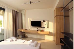 a hotel room with a bed and a desk with a television at Sophe Boutique Stay 2 in Kallithea Halkidikis +12 photos