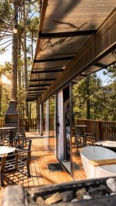a wooden deck with tables and chairs on it at Forte das Araucarias in Urubici