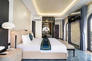 a bedroom with a large white bed and a desk at Diamond Hotel in Bien Hoa