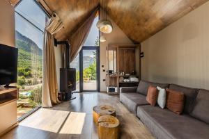 a living room with a couch and a large window at North Alpine Villas in Bogë