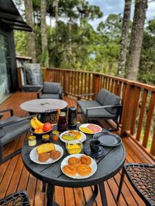 a table with plates of food on a deck at Forte das Araucarias in Urubici