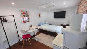 a bedroom with a bed and a desk and a television at 15 Aller Park Rd, Newton Abbot in Newton Abbot