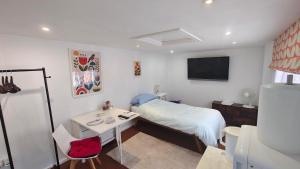 a bedroom with a bed and a desk and a tv at 15 Aller Park Rd, Newton Abbot in Newton Abbot