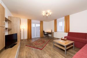 a living room with a red couch and a table at Pension Appartement Lanzer in Moosburg