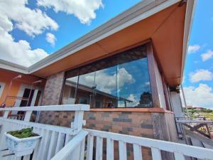 a house with a large window on a balcony at SkyBlue Guesthouse by Concavus in Campos do Jordão
