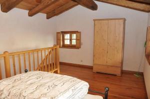 Agriturismo l'Arbo في Andorno Micca: غرفة نوم بسرير وخزانة خشبية