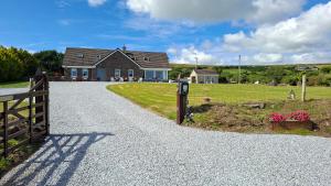 a house with a fence and a driveway at B&B Kerry Lakesview Lodge in Waterville