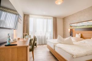 a hotel room with a bed and a desk at Hotel Wiehen-Therme in Hüllhorst