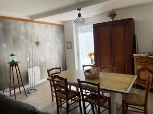 a dining room with a wooden table and chairs at Le Grand Gîte in Pellegrue
