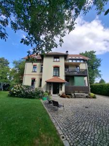 a large building with a balcony and a yard at Ferienwohnung Am Bürgerteich 2 in Bischofswerda