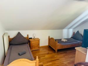 a bedroom with two beds and a wooden floor at Landhaus Magnus in Ramberg