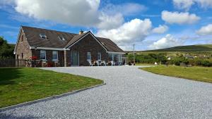 a house with a gravel driveway in front of it at B&B Kerry Lakesview Lodge in Waterville