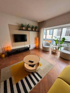 a living room with a couch and a table and a tv at Appartement Moustache in Goes