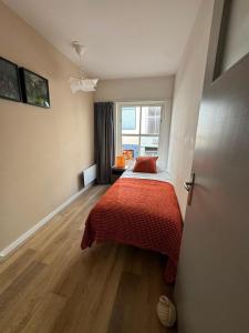 a bedroom with a bed with a red blanket at Appartement Moustache in Goes