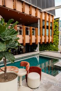 a pool with chairs and a table next to a building at The Charlee Hotel in Medellín