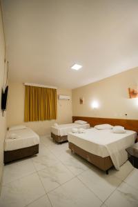 a hospital room with two beds and a window at Hotel Dan Inn Express Foz do Iguaçu By Nacional Inn in Foz do Iguaçu