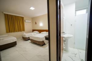 a hotel room with two beds and a sink at Hotel Dan Inn Express Foz do Iguaçu By Nacional Inn in Foz do Iguaçu +62 photos