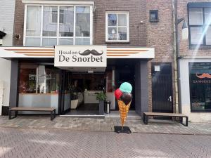 a statue of a ice cream cone in front of a store at Appartement Moustache in Goes