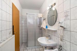 a bathroom with a sink and a shower at Hotel Zum Wikinger in Dornum +63 photos