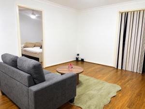 a living room with a couch and a table at 21A Armstrong Place in Schofields