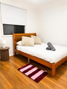 a bedroom with a bed with a rug on the floor at 21A Armstrong Place in Schofields