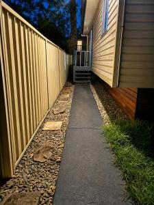 a sidewalk next to a fence next to a house at 21A Armstrong Place in Schofields