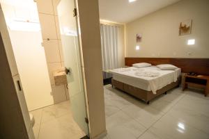 a hospital room with a bed and a bathroom at Hotel Dan Inn Express Foz do Iguaçu By Nacional Inn in Foz do Iguaçu