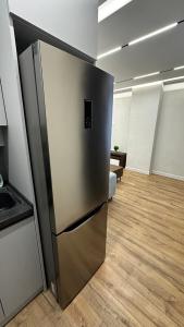 a stainless steel refrigerator in an empty room at Lux Apart in Khujand