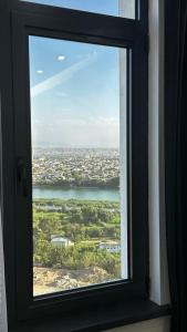 a window with a view of a city and water at Lux Apart in Khujand +6 photos