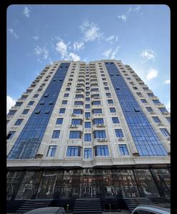 a tall white building with many windows at Lux Apart in Khujand