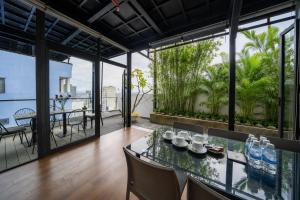 a dining room with a table and chairs and a balcony at Le House Boutique Hotel - 100m to the beach in Danang