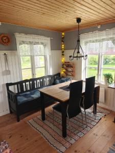 a dining room with a table and chairs and a couch at Gårdshus in Lit
