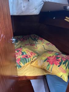 a bed in a room with a pillow on it at Nuits sur un voilier in Pointe-à-Pitre